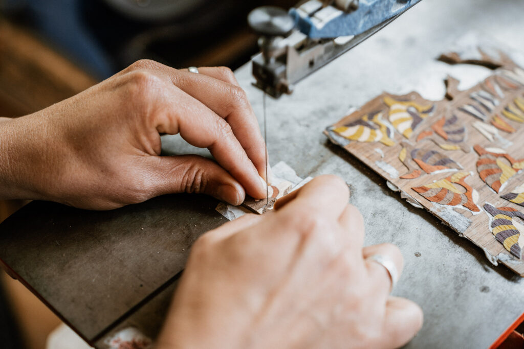 main d'une artisane qui travaille le bois dans son atelier de chartreuse